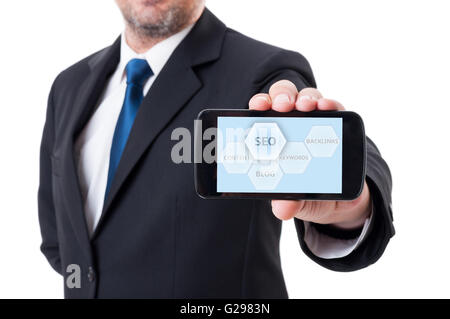 Uomo con smartphone con SEO o search engine optimization schema Foto Stock