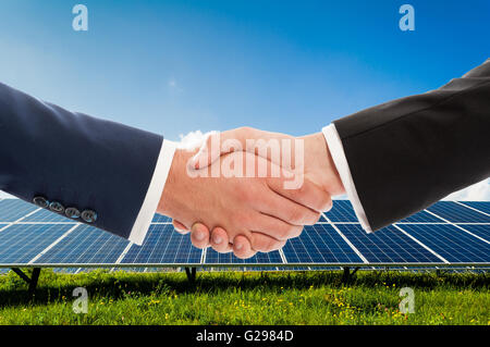 Imprenditori handshake solarpower sul pannello fotovoltaico background come bio-energia team aziendale accordo Foto Stock