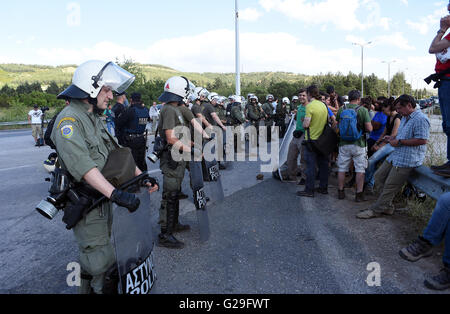 Idomeni, Grecia. Xxiv Maggio, 2016. Persone protestano in corrispondenza del punto in cui poliziotti antisommossa bloccato la strada che porta al confine campo di Idomeni, vicino il greco-EX REPUBBLICA IUGOSLAVA DI MACEDONIA le frontiere, il 24 maggio 2016. Polizia greca evacuato il ripiego Refugee Camp in Idomeni e trasferito la maggior parte di essi alle nuove strutture di hosting in Sindos Derveni e vicino al nord della città greca di Salonicco. Solo 1.500 migranti sono stati lasciati in Idomeni. ©Elias Verdi/Alamy Live News Foto Stock