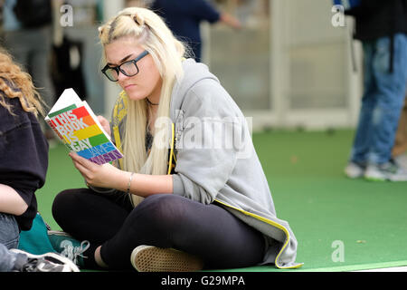 Hay on Wye, Wales, Regno Unito. 27 Maggio, 2016. Un festival giovane visitatore gode la possibilità di sedersi e leggere il suo nuovo libro come il sole splende il giorno 2 del fieno Festival. Fotografia Steven Maggio / Alamy Live News Foto Stock