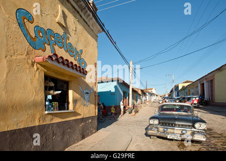 Tipica strada vicino al centro di Trinidad di Cuba con un takeaway, caffetteria, di un ristorante e di un 1958 Oldsmobile auto americane. Foto Stock