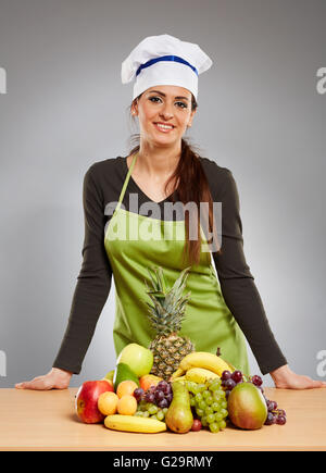 Donna cook con un mazzetto di vari tipi di frutta sulla tavola di legno Foto Stock