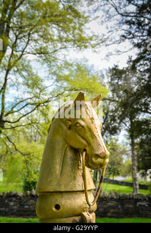 Un vecchio e stagionato ghisa cavallo post di aggancio dal xix secolo sta di guardia e nobile sul maestoso motivi Foto Stock