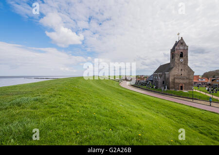 Chiesa di Wierum con Waddensea dike in Frisia nei Paesi Bassi. Foto Stock