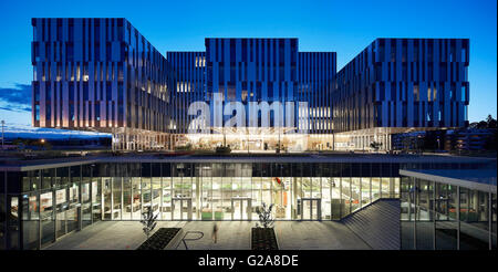 In elevazione frontale e con volumi di flottante e abbassato atrium di notte. Fornebuporten, Oslo, Norvegia. Architetto: DARK, 2015. Foto Stock