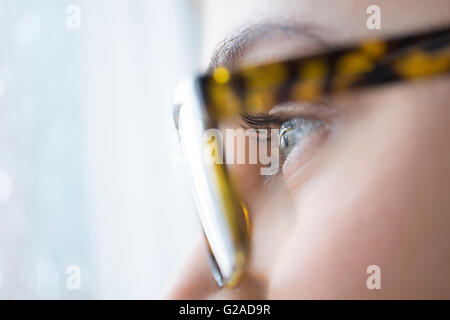Close up della giovane donna con gli occhi blu con gli occhiali Foto Stock