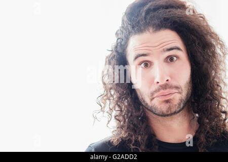 Ritratto di giovane uomo con lunghi capelli ricci Foto Stock