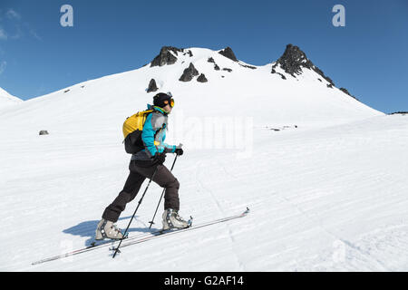 Alpinista di sci salire sugli sci sulla montagna contro lo sfondo del monte di cammello. Russia, Estremo Oriente, penisola di Kamchatka, Avacha pass. Foto Stock