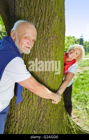 Felice coppia senior in amore tenendo le mani in un parco Foto Stock