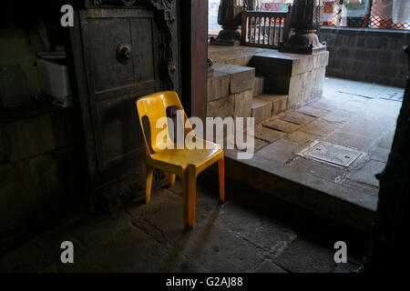 Un giallo sedia in plastica a Vishrambaug Wada a Pune, Maharashtra, India. Foto Stock