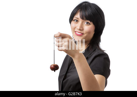 Felice modello di business con un conker su una stringa detenute fino di fronte a lei. Foto Stock