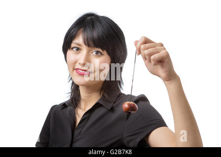 Felice modello di business con un conker su una stringa detenute fino di fronte a lei. Foto Stock