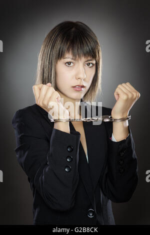 Bloccato business donna in manette con le mani in alto Foto Stock