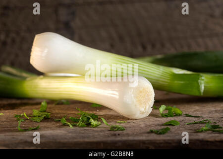 Cipolline noto anche come insalata cipolle, cipollotti o scalogni su uno sfondo di legno Foto Stock