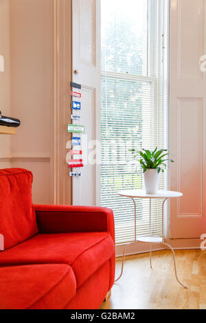 Pembridge Square, Notting Hill. Parial vista di un divano rosso in salotto. Foto Stock