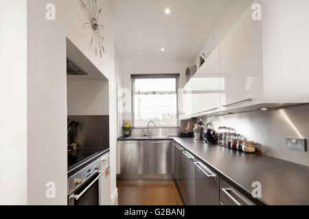 Walden House, Marylebone High Street. Cucina moderna con acciaio inossidabile countertops e apparecchi e armadi di bianco. Foto Stock