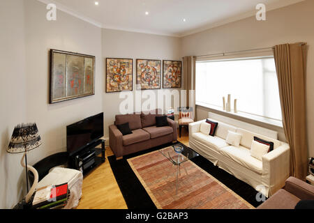 Walden House, Marylebone High Street. Vista di un salotto guardando verso il basso. Contemporaneo, dai toni neutri dei mobili con una grande finestra. Foto Stock