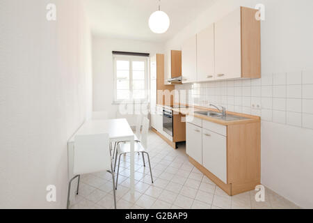 Wisbyer Strasse 59. Moderna cucina minimale con funzioni di bianco e le piastrelle. Tavolo e sedie. Foto Stock