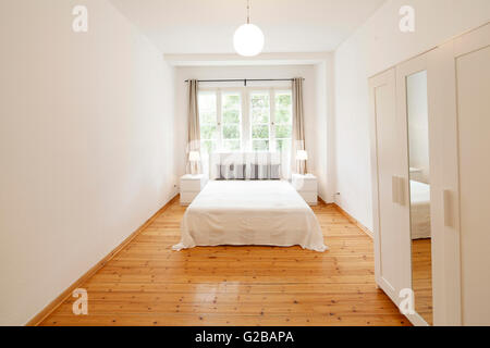 Wisbyer Strasse 59. Camera da letto con il minimo di mobili e pavimenti in legno. Foto Stock