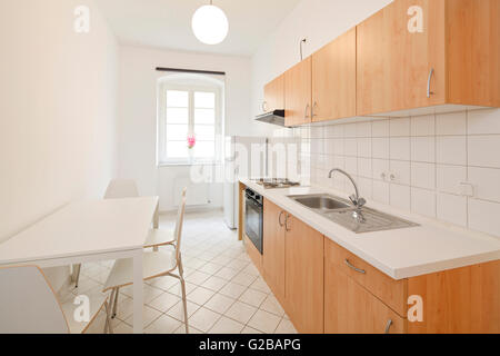 Wisbyer Strasse 59. Cucina moderna con un decor essenziale. Tavolo e sedia e armadi di legno. Foto Stock