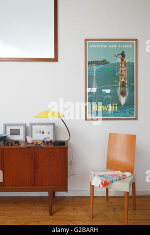 Angolo di cucina con dispensa e poster di viaggio delle Hawaii. Arredi in stile contemporaneo. Giallo lampada da tavolo. Foto Stock