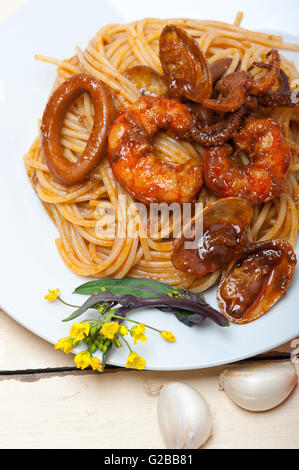 Pesce italiano gli spaghetti in salsa di pomodoro rosso su bianco tavola in legno rustico Foto Stock