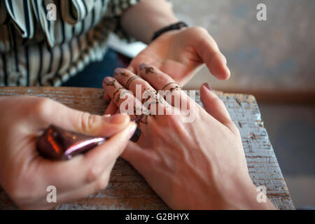 Artista creazione tradizionale pittura hennè Mehndi sulle mani femminili Foto Stock