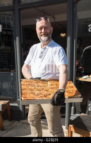 Tim Hayward il proprietario del nuovo Fitzbillies cafe e ristorante Cambridge UK holding un vassoio di ciambelle di Chelsea Foto Stock