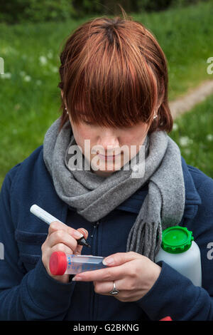 Biologo durante una gita in una riserva naturale in Basso Reno etichettare i loro campioni d'acqua. Foto Stock