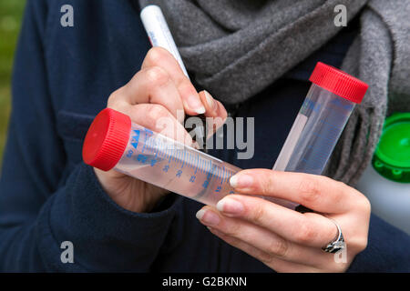 Biologo durante una gita in una riserva naturale in Basso Reno etichettare i loro campioni d'acqua. Foto Stock