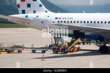 DUBROVNIK AEROPORTO INTERNAZIONALE COATIA UN Croatia Airlines jet sul piazzale con bagagli il caricamento della stiva dell aeromobile Foto Stock