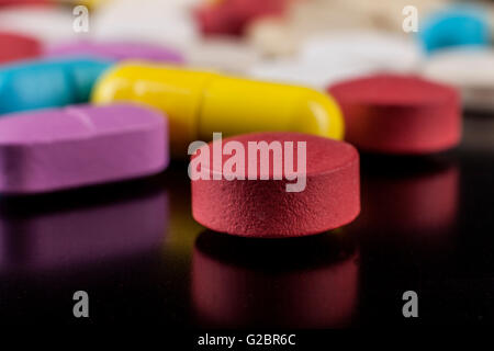 Pillole colorate Closeup su sfondo nero con la riflessione Foto Stock