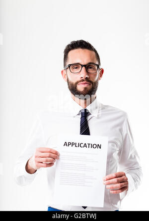 Lavoratore di ufficio o imprenditore con gli occhiali che mostra un modulo di domanda Foto Stock