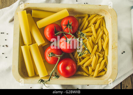 Cannelloni, le penne e i pomodori in una teglia il fuoco selettivo Foto Stock