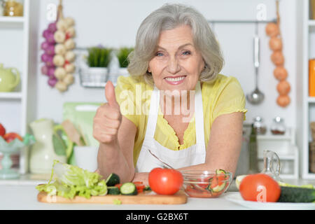 Donna Senior per la cottura in cucina Foto Stock