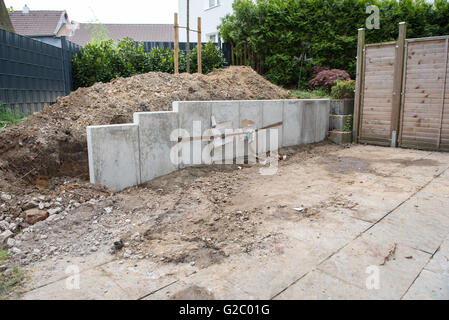 La costruzione di un nuovo giardino con pietre, recinzioni e alberi Foto Stock