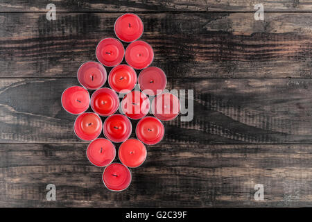 Molti estinti piccole candele rosse closeup sul tavolo di legno Foto stock  - Alamy