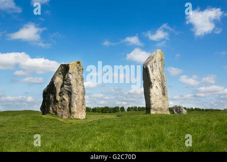 Una coppia di pietre permanente, parte del grande cerchio di pietre di Avebury Wiltshire. Cielo blu con nuvole soffici e lussureggiante verde erba. Foto Stock