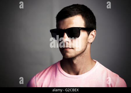 Dark ritratto di un giovane uomo in occhiali da sole, isolamento sociale e il concetto di anonimato Foto Stock