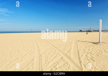 Le tracce dalla vettura sulla sabbia che conduce al mare. Foto Stock