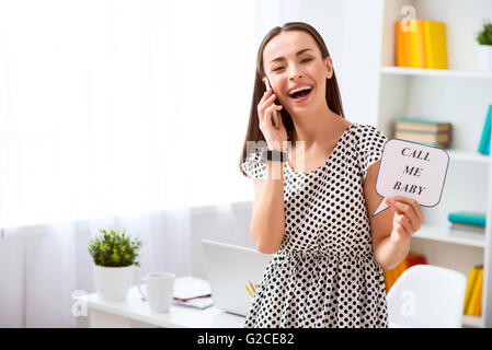 Donna allegra parlando al cellulare Foto Stock