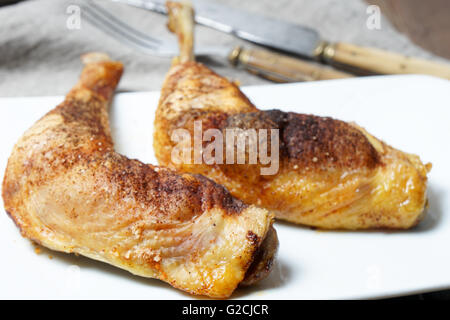 Due golden arrosto coscia di pollo servito sulla piastra bianca Foto Stock
