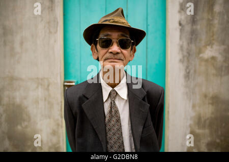 Uomo vietnamita in tuta, cappello e occhiali da sole Foto Stock