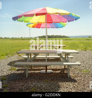 Tavoli da picnic con ombrelloni colorati Foto Stock