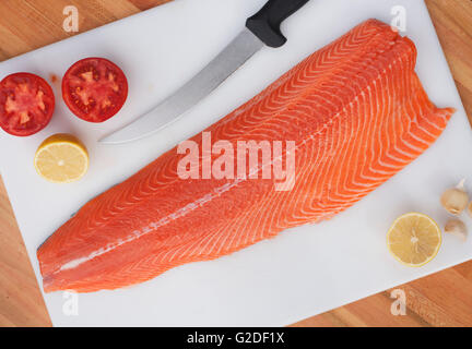 Materie di filetto di salmone sul piatto di portata con il coltello Foto Stock