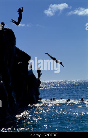Gruppo di Persone che saltano fuori Cliff in acqua Foto Stock