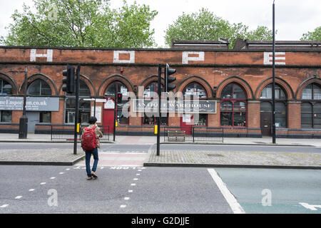 Un giovane uomo cammina attraverso le deserte le strade che circondano l'Eurostar International Terminal ferroviario a St Pancras Foto Stock