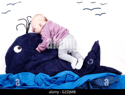 Bambino di 4 mesi ragazza a cavallo di Whale Foto Stock