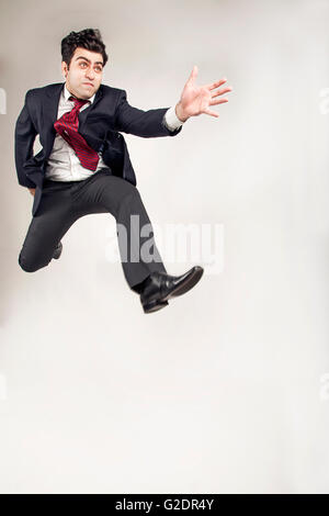 Business man in suit jumping alto e in avanti Foto Stock