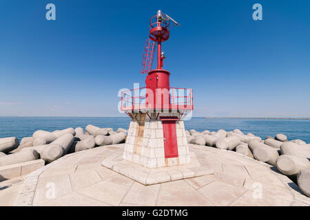 Faro rosso che indica l'entrata del porto. Foto Stock